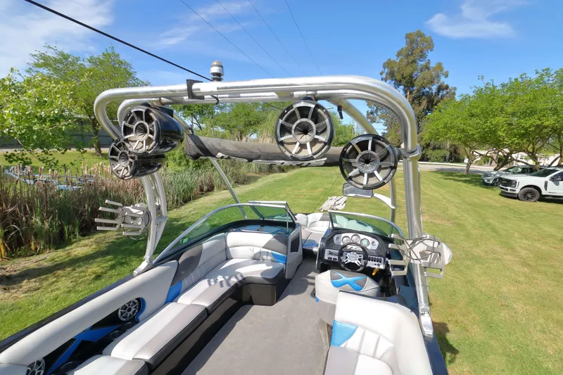 Slide: The Image of 2012 MB B-52 23 Widebody boat with speakers and seating, parked on grass. - 9