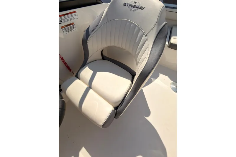 Slide: The Image of 2023 Stingray 201 DC boat with red and white hull on a trailer. - 10