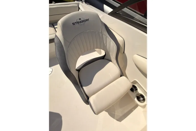 Slide: The Image of 2023 Stingray 201 DC boat interior with beige seating and speakers. - 11
