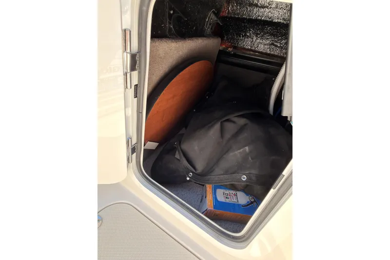 Slide: The Image of Storage compartment of 2023 Stingray 201 DC boat with various items inside. - 20