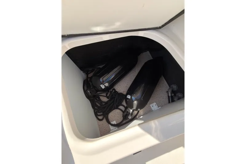 Slide: The Image of Storage compartment in a 2023 Stingray 201 DC boat with black fenders and ropes. - 21