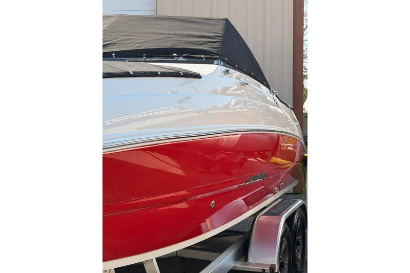 Slide: The Image of 2023 Stingray 201 DC boat on calm water, with houses in the background. - 4