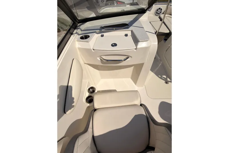 Slide: The Image of 2023 Stingray 201 DC boat in red and white on a trailer, parked outdoors. - 7