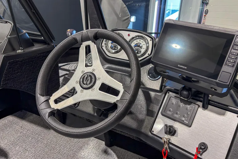 Slide: The Image of 2026 Smoker Craft Excursion 176 DC dashboard with steering wheel and Garmin display. - 14