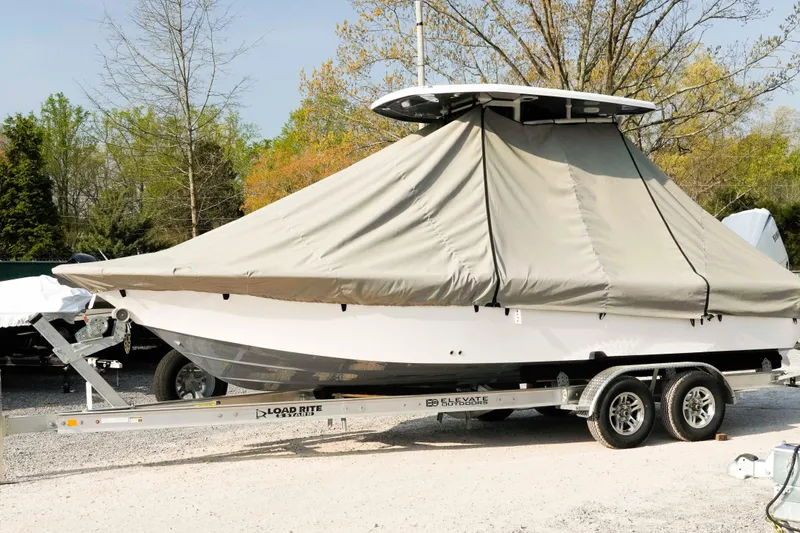 Slide: The Image of 2026 Tidewater 2300 Carolina Bay boat covered on trailer, parked outdoors. - 3