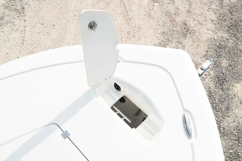 Slide: The Image of 2026 Tidewater 2300 Carolina Bay boat anchor compartment, open lid, gravel background. - 37
