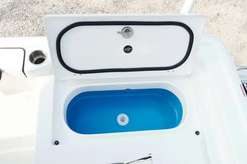 Slide: The Image of Livewell compartment on 2026 Tidewater 2300 Carolina Bay boat, open with blue interior. - 38