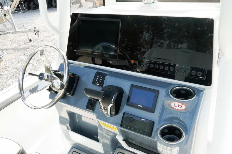 Slide: The Image of 2026 Tidewater 2300 Carolina Bay boat dashboard with steering wheel and electronic controls. - 7