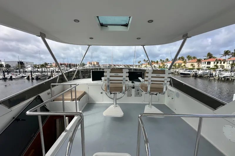 Slide: The Image of Pilothouse view of 2005 Jefferson Pilothouse 63 yacht, featuring helm chairs and marina backdrop. - 10
