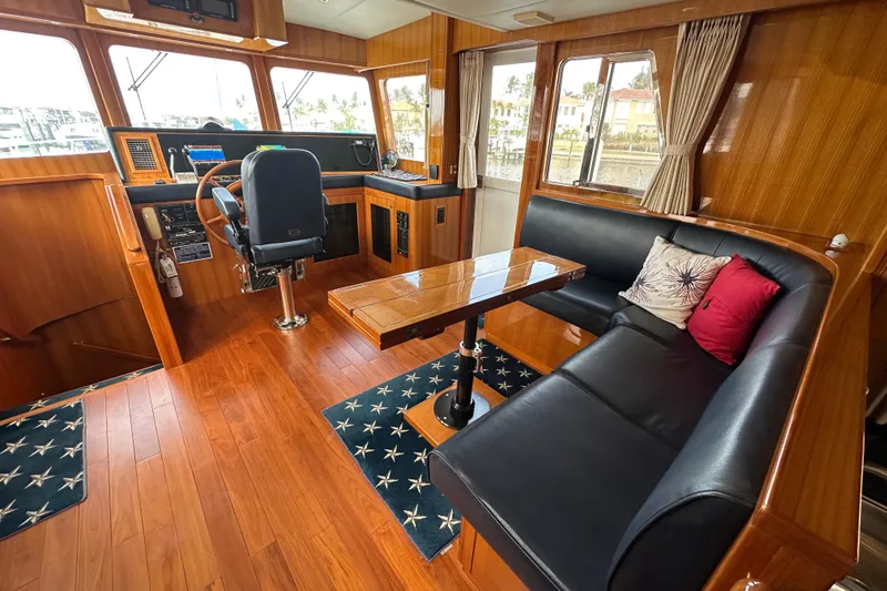 Slide: The Image of Pilothouse interior of 2005 Jefferson Pilothouse 63 yacht with wood paneling and seating area. - 21
