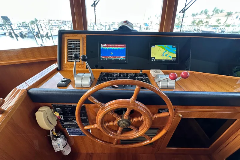 Slide: The Image of Pilothouse of 2005 Jefferson Pilothouse 63 yacht with wooden steering wheel and navigation screens. - 26