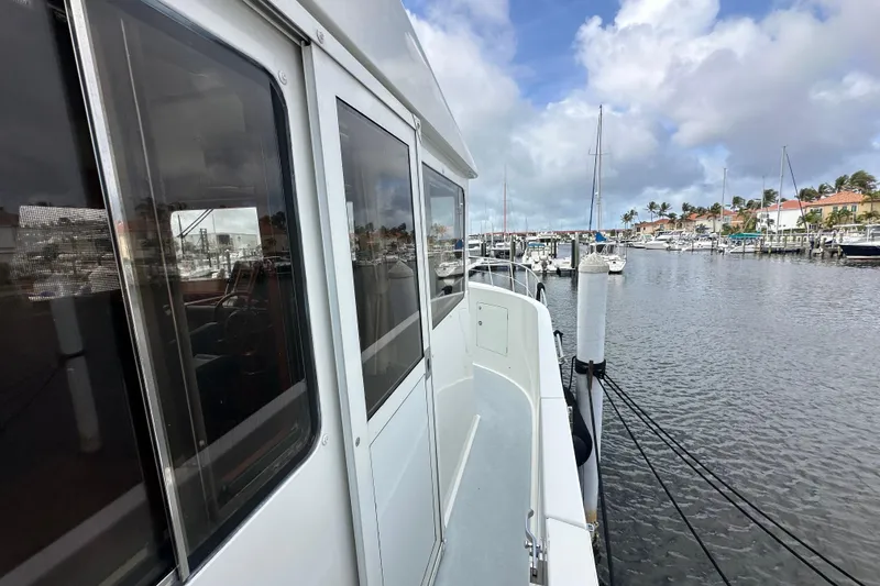 Slide: The Image of 2005 Jefferson Pilothouse 63 yacht docked at a marina under a partly cloudy sky. - 44
