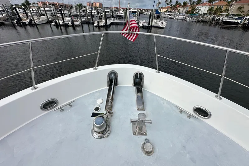 Slide: The Image of Bow view of 2005 Jefferson Pilothouse 63 yacht in marina with American flag. - 46