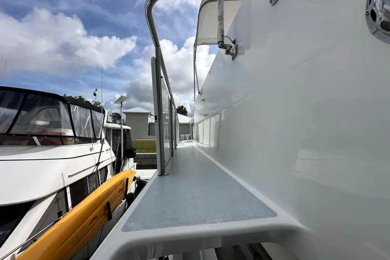 Slide: The Image of Side deck view of a 2005 Jefferson Pilothouse 63 yacht under a partly cloudy sky. - 47