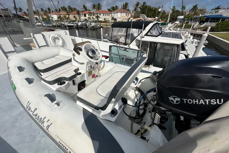 Slide: The Image of Inflatable boat with Tohatsu motor on Jefferson Pilothouse 63, 2005 model, docked at marina. - 48
