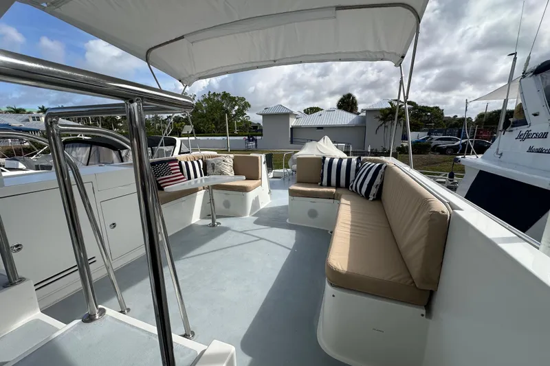 Slide: The Image of Spacious deck of 2005 Jefferson Pilothouse 63 yacht with cushioned seating and canopy. - 5