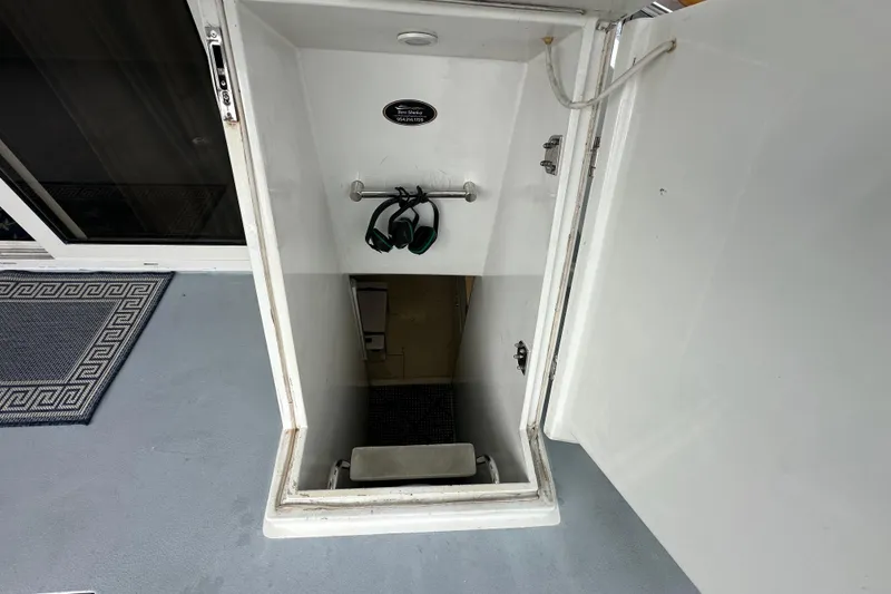 Slide: The Image of Access hatch on 2005 Jefferson Pilothouse 63 yacht, showing interior stairs and headphones. - 50