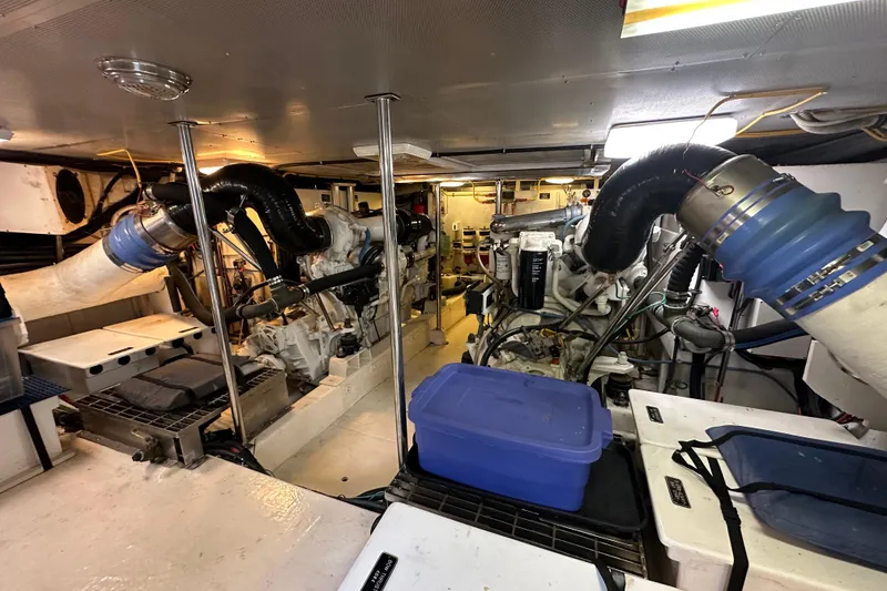 Slide: The Image of Engine room of a 2005 Jefferson Pilothouse 63 yacht, featuring dual engines and storage containers. - 52