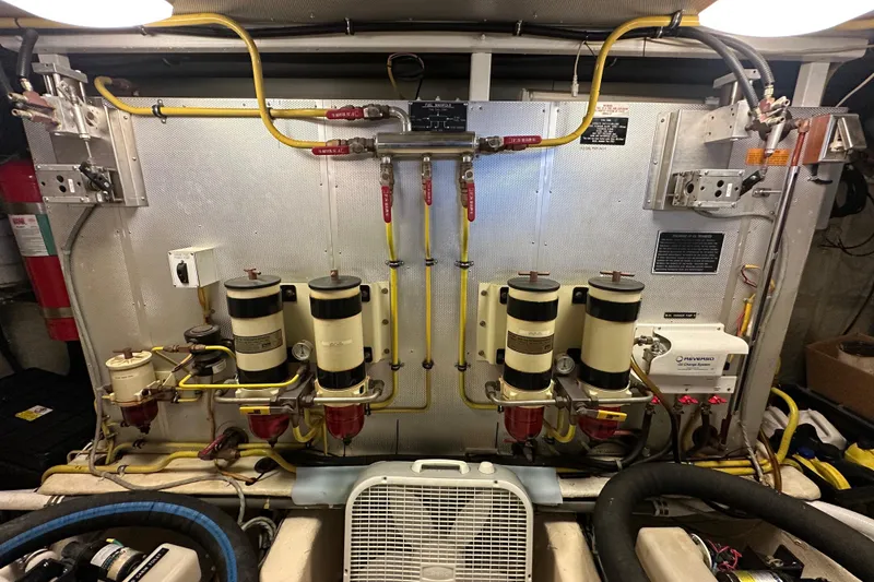 Slide: The Image of Engine room of a 2005 Jefferson Pilothouse 63 yacht, featuring fuel filters and piping. - 57