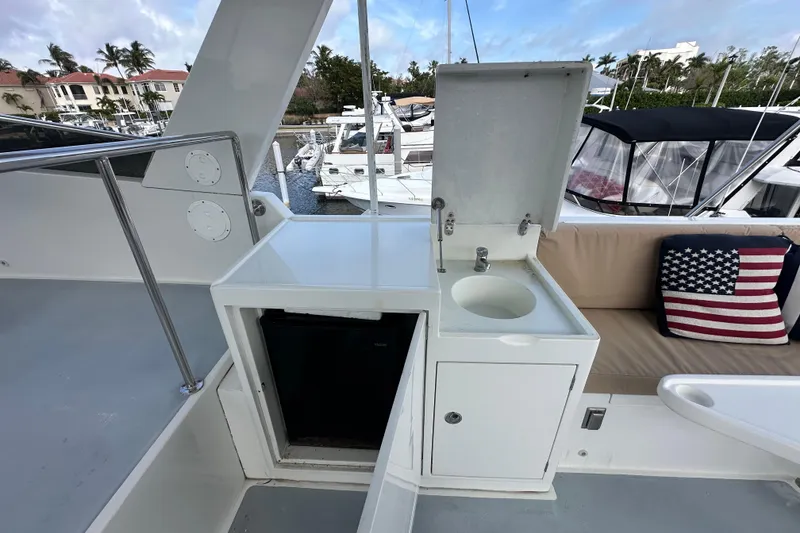 Slide: The Image of Outdoor kitchenette on 2005 Jefferson Pilothouse 63 yacht with sink and American flag pillow. - 9