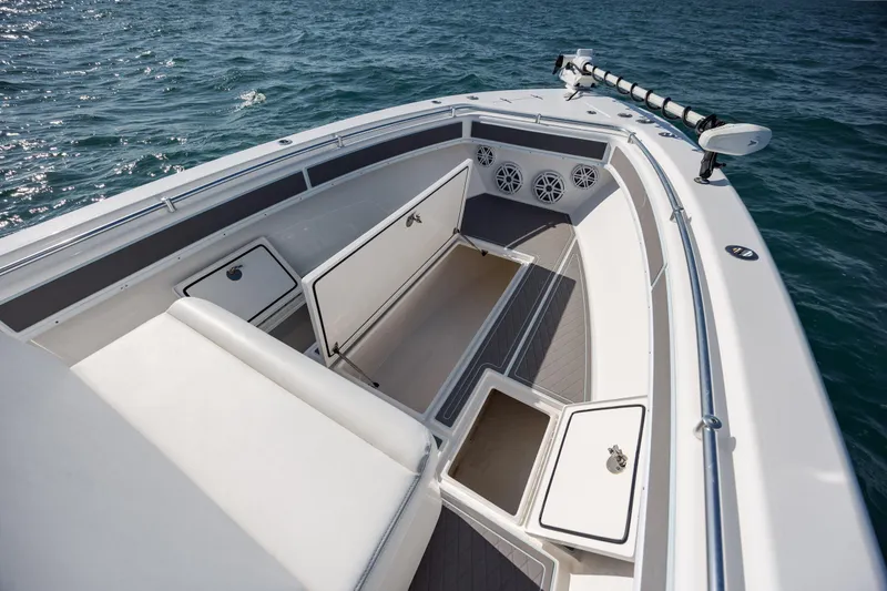 Slide: The Image of 2024 Contender 28 Tournament boat with open storage compartments on calm water. - 15