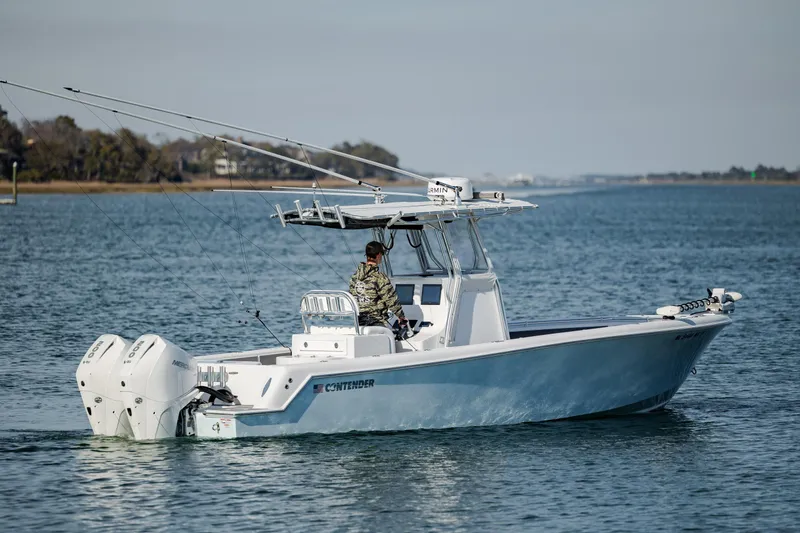 Slide: The Image of 2024 Contender 28 Tournament boat cruising on calm waters with dual engines. - 2