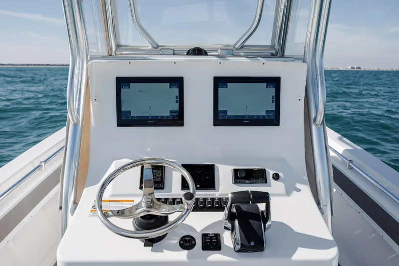 Slide: The Image of 2024 Contender 28 Tournament boat dashboard with dual navigation screens on open water. - 23