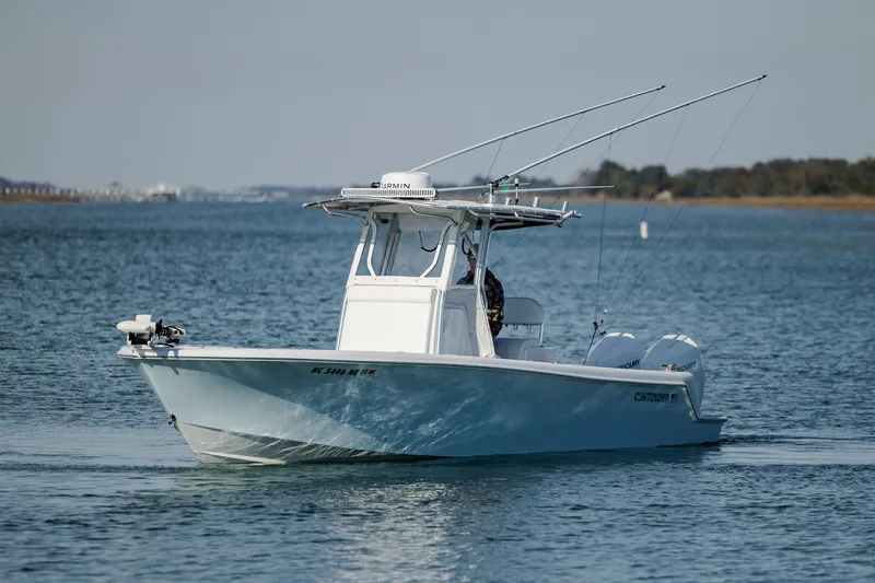 Slide: The Image of 2024 Contender 28 Tournament boat on calm water, equipped with fishing rods and dual engines. - 8