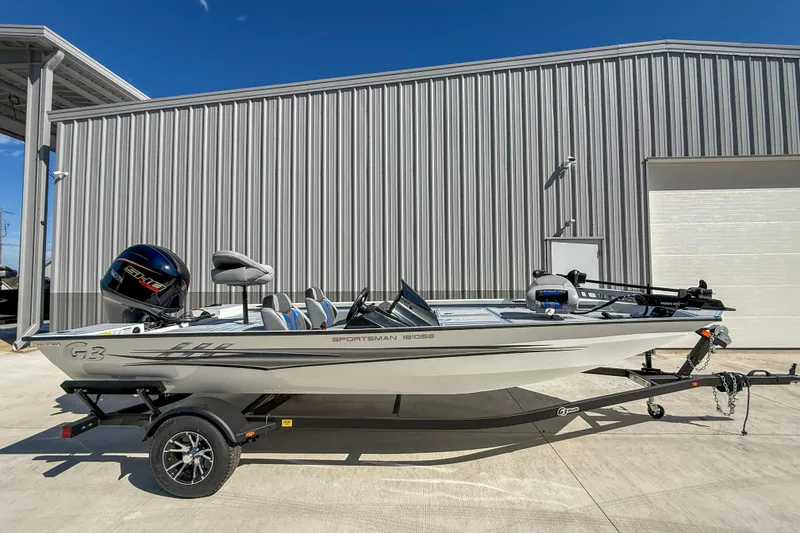 The Image of 2026 G3 Sportsman 1810 SE boat on trailer, parked outside a metal building. - 1