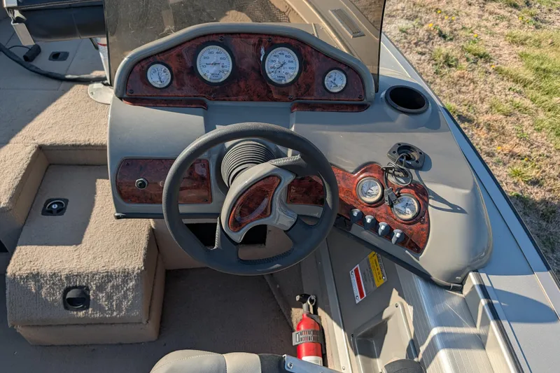 Slide: The Image of 2003 Tracker Targa 17 SC boat dashboard with gauges and steering wheel. - 18