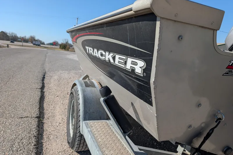 Slide: The Image of 2003 Tracker Targa 17 SC boat on trailer, parked on roadside under clear blue sky. - 6
