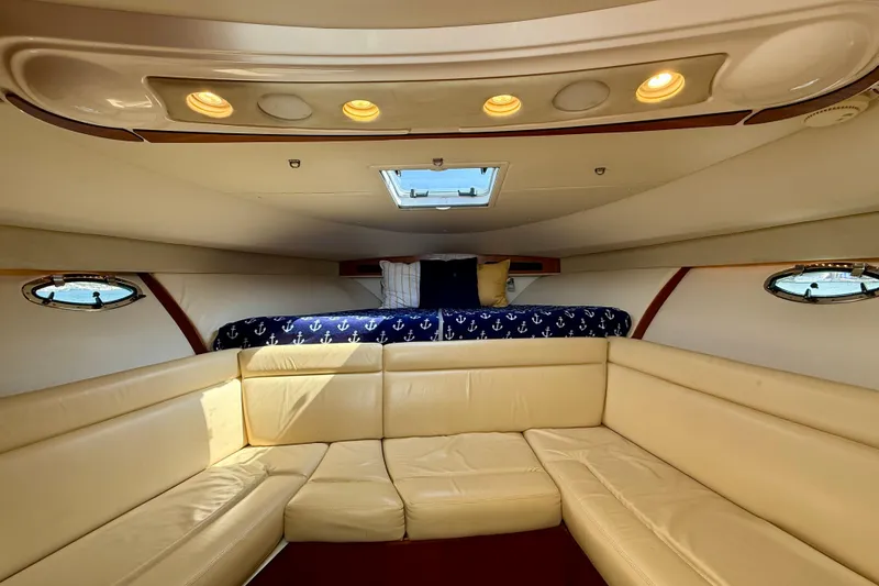 Slide: The Image of Interior of 2007 Tiara Yachts 3000 Open, featuring beige seating and nautical-themed bedding. - 11