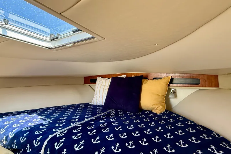Slide: The Image of Cozy cabin interior of 2007 Tiara Yachts 3000 Open with nautical-themed bedding. - 12