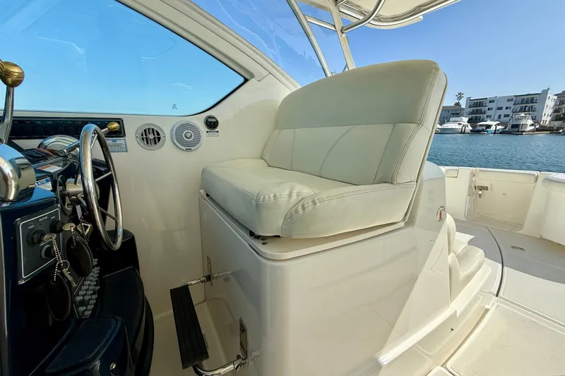 Slide: The Image of 2007 Tiara Yachts 3000 Open helm with white seating and steering wheel, dockside view. - 38