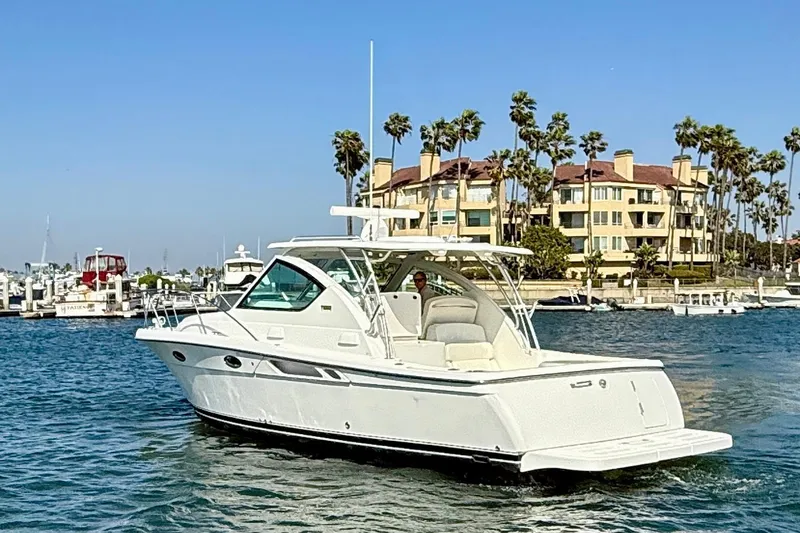 Slide: The Image of 2007 Tiara Yachts 3000 Open cruising near waterfront buildings and palm trees. - 4