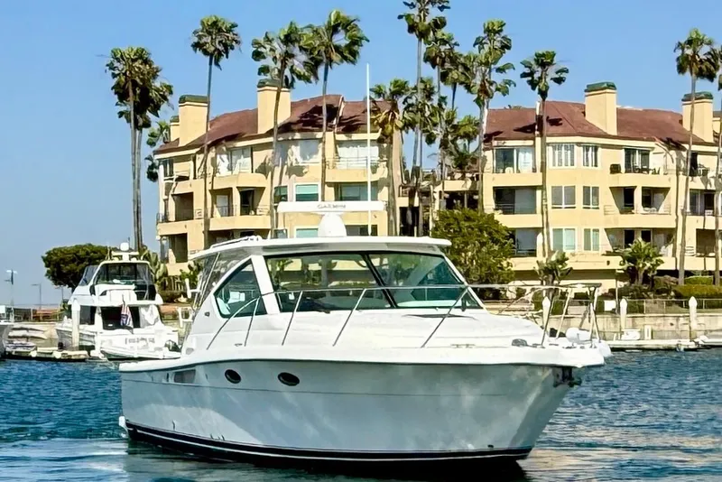 Slide: The Image of 2007 Tiara Yachts 3000 Open cruising near waterfront buildings and palm trees. - 5