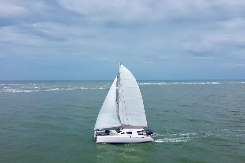 The Image of Sailing catamaran Nautitech 47 from 2009 gliding on open sea under cloudy skies. - 0