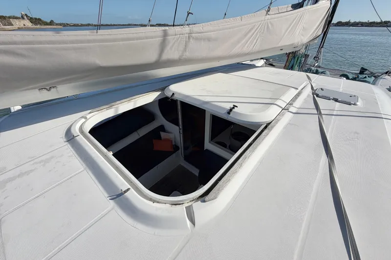 Slide: The Image of Nautitech 47 catamaran deck with open hatch, showcasing interior seating, 2009 model. - 112