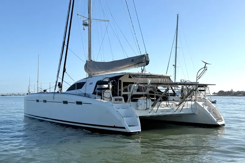 Slide: The Image of 2009 Nautitech 47 catamaran sailing on calm waters under clear blue sky. - 12