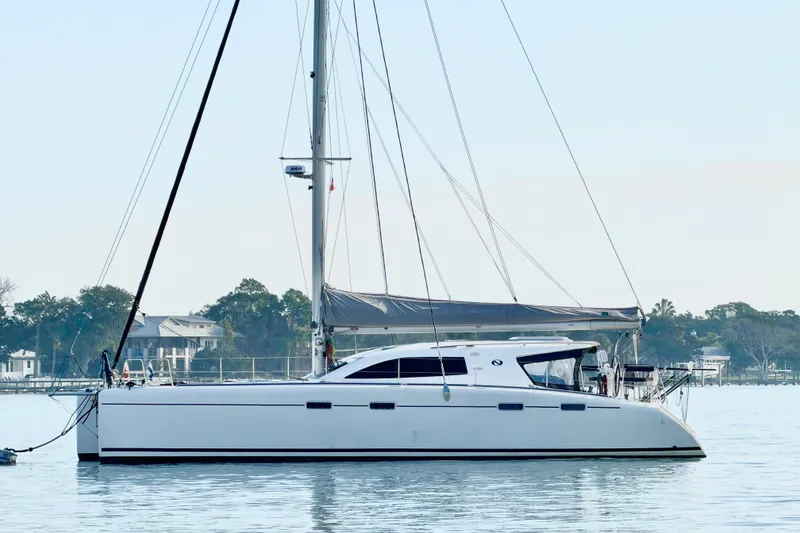 Slide: The Image of 2009 Nautitech 47 catamaran sailing on calm waters near a coastal area. - 14