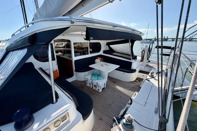 Slide: The Image of Spacious deck of 2009 Nautitech 47 catamaran with seating and table, docked at marina. - 16