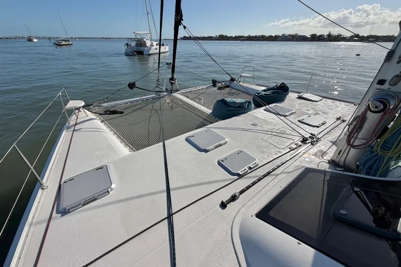 Slide: The Image of 2009 Nautitech 47 catamaran deck with netting, moored in calm waters. - 18