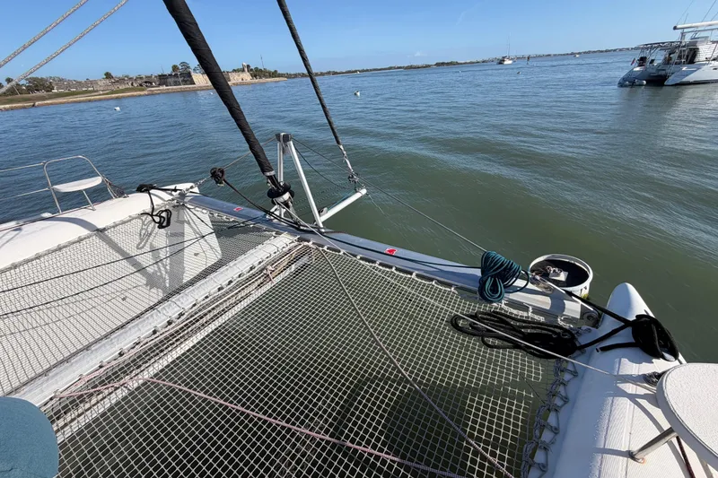 Slide: The Image of 2009 Nautitech 47 catamaran on calm waters, featuring deck and netting. - 22