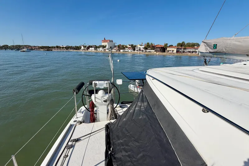 Slide: The Image of Nautitech 47 catamaran from 2009 docked near a scenic coastal town. - 25