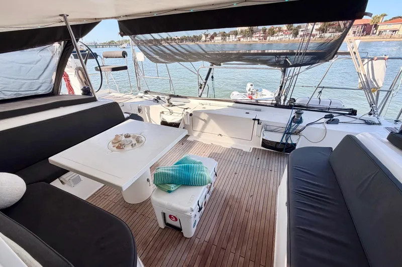 Slide: The Image of Spacious deck of 2009 Nautitech 47 catamaran with seating and table, overlooking serene waters. - 34