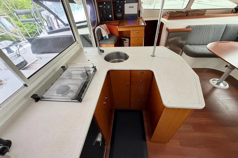 Slide: The Image of Modern kitchen area in a 2009 Nautitech 47 catamaran, featuring a sleek countertop and stove. - 48