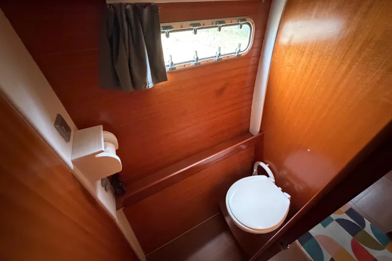 Slide: The Image of Bathroom interior of 2009 Nautitech 47 yacht with wooden paneling and porthole window. - 59