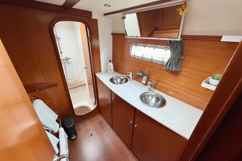 Slide: The Image of Luxurious Nautitech 47 yacht bathroom with dual sinks, wooden cabinetry, and modern fixtures, 2009 model. - 60