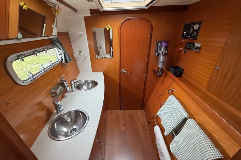 Slide: The Image of Luxurious 2009 Nautitech 47 yacht bathroom with dual sinks and wooden interior. - 61