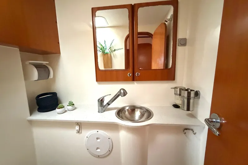 Slide: The Image of Compact bathroom in a 2009 Nautitech 47 yacht with sink, mirror, and storage. - 76
